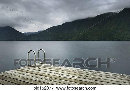 Stock Photo - Ladder on wooden pier at still remote lake. Fotosearch