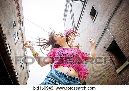 Low angle view of Caucasian woman dancing outdoors View Large Photo Image Stock Image - Low angle view of Caucasian woman dancing outdoors. Fotosearch