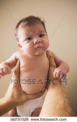 Stock Photograph - Low angle view of father lifting baby. Fotosearch