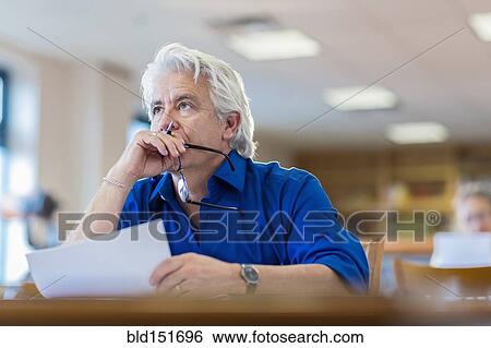 Man reading paperwork in library View Large Photo Image Stock Photograph - Man reading paperwork in library. Fotosearch
