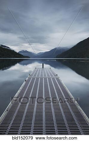Stock Photo - Metal pier over still remote lake. Fotosearch