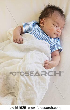 Stock Photo - Mixed race baby sleeping in bed. Fotosearch