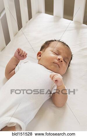 Stock Photo - Mixed race baby sleeping in crib. Fotosearch