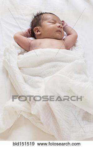Stock Photo - Mixed race baby sleeping on bed. Fotosearch