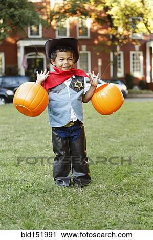 Mixed race boy in cowboy costume holding pumpkin pails on Halloween View Large Photo Image Stock Image - Mixed race boy in cowboy costume holding pumpkin pails on Halloween. Fotosearch