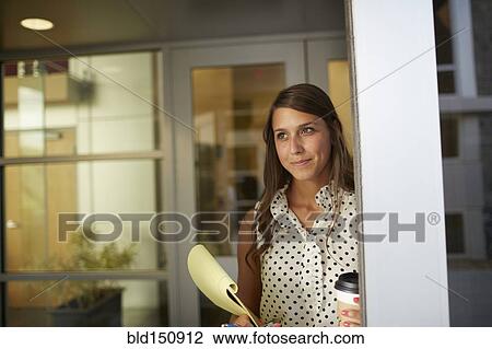 Stock Image - Mixed race businesswoman standing in office. Fotosearch