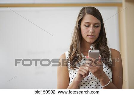 Stock Image - Mixed race businesswoman using cell phone. Fotosearch