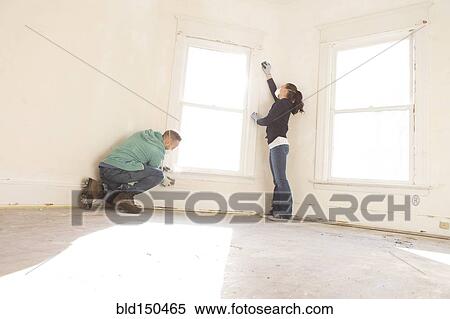 Mixed race couple cleaning wall new home View Large Photo Image Stock Photography - Mixed race couple cleaning wall new home. Fotosearch