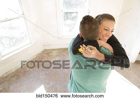 Mixed race couple hugging in new home View Large Photo Image Stock Photograph - Mixed race couple hugging in new home. Fotosearch