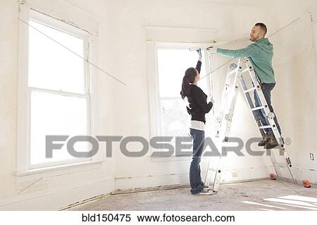 Mixed race couple installing shade in new home View Large Photo Image Stock Photography - Mixed race couple installing shade in new home. Fotosearch