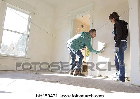 Mixed race couple painting walls of new home View Large Photo Image Stock Image - Mixed race couple painting walls of new home. Fotosearch
