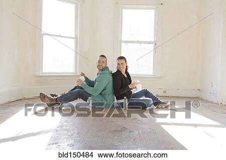 Mixed race couple sitting on floor of new home View Large Photo Image Picture - Mixed race couple sitting on floor of new home. Fotosearch
