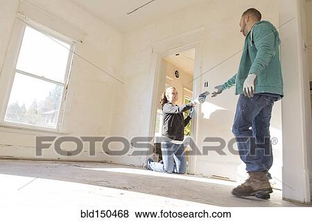 Stock Photo - Mixed race couple working on new home. Fotosearch