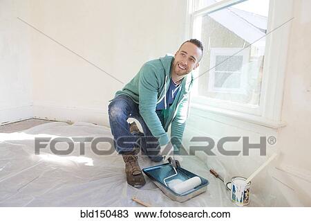 Mixed race man painting walls of home View Large Photo Image Stock Image - Mixed race man painting walls of home. Fotosearch