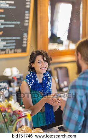Stock Photograph - Mixed race server talking to customer in cafe. Fotosearch