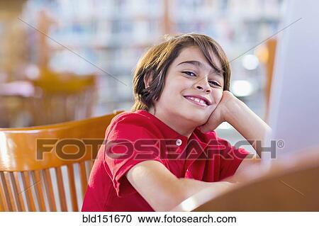 Mixed race student smiling at computer in library View Large Photo Image Stock Image - Mixed race student smiling at computer in library. Fotosearch