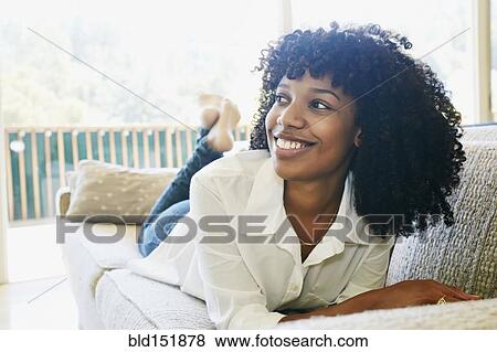 Mixed race woman laying on sofa View Large Photo Image Stock Photo - Mixed race woman laying on sofa. Fotosearch