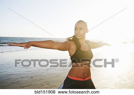 Mixed race woman practicing yoga on beach View Large Photo Image Stock Photo - Mixed race woman practicing yoga on beach. Fotosearch