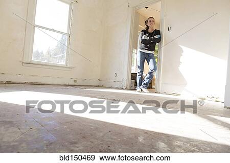 Mixed race woman standing in new home View Large Photo Image Stock Photo - Mixed race woman standing in new home. Fotosearch