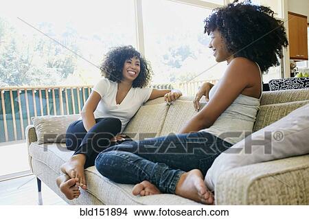 Mixed race women relaxing on sofa View Large Photo Image Picture - Mixed race women relaxing on sofa. Fotosearch