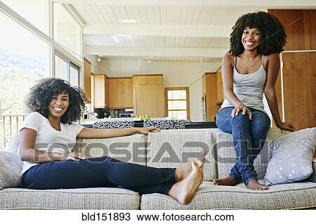 Mixed race women relaxing on sofa View Large Photo Image Stock Image - Mixed race women relaxing on sofa. Fotosearch