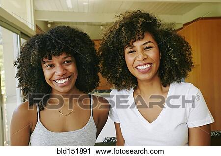 Stock Image - Mixed race women smiling. Fotosearch