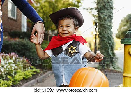 Stock Photo - Mother with son dressed as cowboy for Halloween. Fotosearch