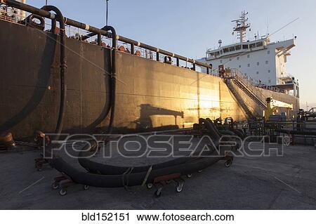 Stock Image - Oil tanker ship docked in industrial harbor. Fotosearch