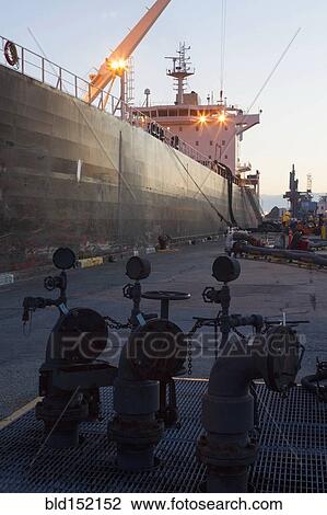 Stock Image - Oil tanker ship docked in industrial harbor. Fotosearch