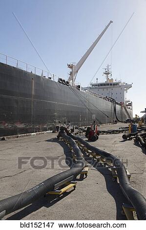 Oil tanker ship docked in industrial harbor View Large Photo Image Stock Photo - Oil tanker ship docked in industrial harbor. Fotosearch