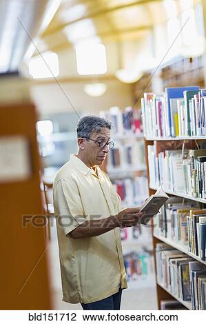 Older Caucasian man reading book in library View Large Photo Image Stock Image - Older Caucasian man reading book in library. Fotosearch