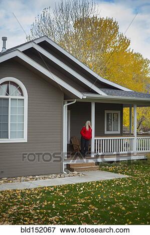 Stock Photo - Older Caucasian woman standing on porch. Fotosearch