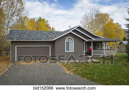 Stock Photograph - Older Caucasian woman standing on porch. Fotosearch