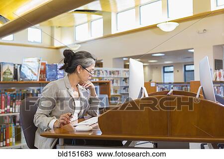 Older Caucasian woman using computer in library View Large Photo Image Stock Image - Older Caucasian woman using computer in library. Fotosearch