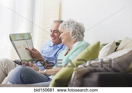Older couple reading paperwork on sofa View Large Photo Image Stock Image - Older couple reading paperwork on sofa. Fotosearch