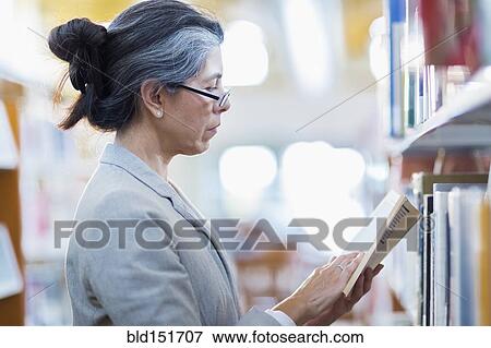 Older Hispanic woman reading book in library View Large Photo Image Stock Photo - Older Hispanic woman reading book in library. Fotosearch