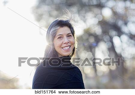 Picture - Older Hispanic woman smiling outdoors. Fotosearch