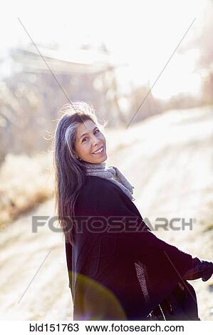 Stock Image - Older Hispanic woman walking outdoors. Fotosearch