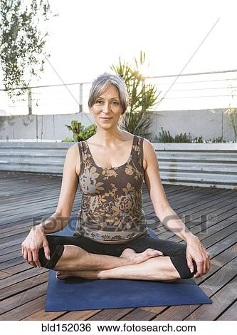 Older mixed race woman sitting on yoga mat on rooftop View Large Photo Image Stock Photograph - Older mixed race woman sitting on yoga mat on rooftop. Fotosearch