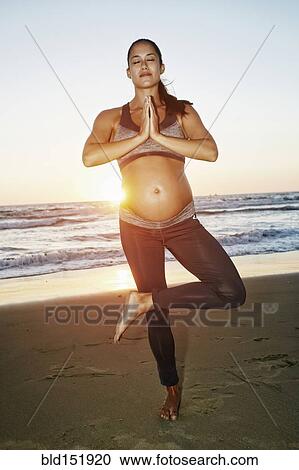 Pregnant Hispanic woman practicing yoga on beach View Large Photo Image Stock Image - Pregnant Hispanic woman practicing yoga on beach. Fotosearch