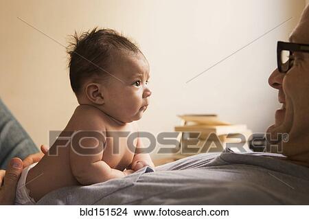 Picture - Smiling father playing with baby. Fotosearch