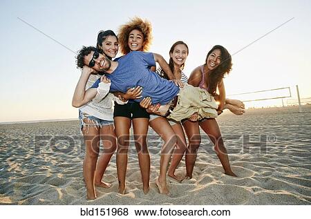 Smiling friends posing together on beach View Large Photo Image Stock Photo - Smiling friends posing together on beach. Fotosearch