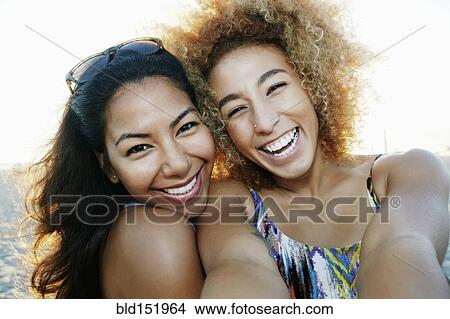 Smiling Hispanic women taking selfie together outdoors View Large Photo Image Picture - Smiling Hispanic women taking selfie together outdoors. Fotosearch