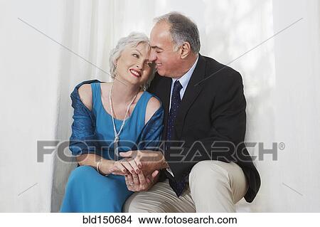 Picture - Smiling older couple in formal wear hugging. Fotosearch