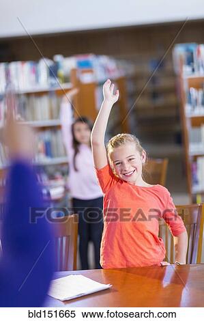 Student raising her hand in library View Large Photo Image Stock Photography - Student raising her hand in library. Fotosearch