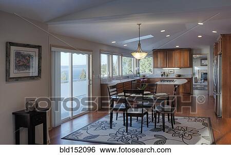 Stock Photograph - Table and chairs in open kitchen and dining room. Fotosearch