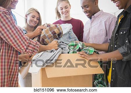 Stock Photograph - Teenagers donating clothes to charity. Fotosearch