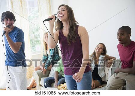 Teenagers singing karaoke at party View Large Photo Image Stock Photography - Teenagers singing karaoke at party. Fotosearch