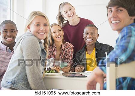 Teenagers smiling at table View Large Photo Image Stock Photography - Teenagers smiling at table. Fotosearch