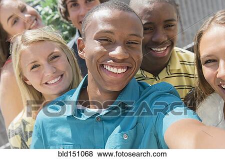 Stock Photo - Teenagers taking selfie together outdoors. Fotosearch